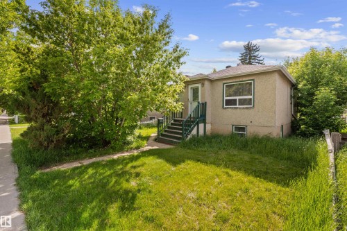 Split-level residence featuring a stucco exterior and green trim accents - 7516 106 Street, Edmonton, AB 