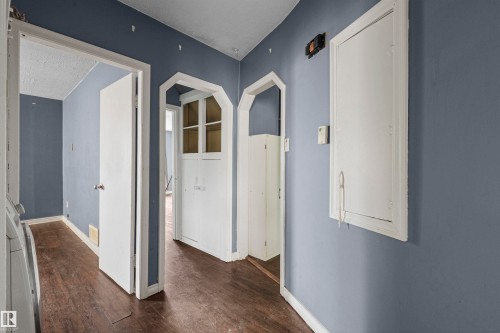 Hallway featuring wood-finish flooring and solid core doors - 7520 106 Street, Edmonton, AB 