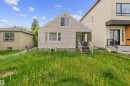 Gabled home featuring light-toned horizontal siding and a covered front entry - 7520 106 Street, Edmonton, AB 