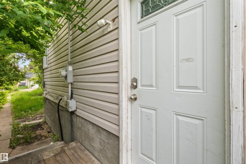 White paneled entry door with decorative glass insert and combination lockset - 7520 106 Street, Edmonton, AB 