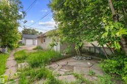 Detached garage with two white garage doors and a grey shingled roof - 