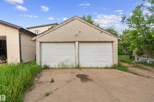 Detached two-car garage with white paneled doors and a stucco exterior - 7520 106 Street, Edmonton, AB 