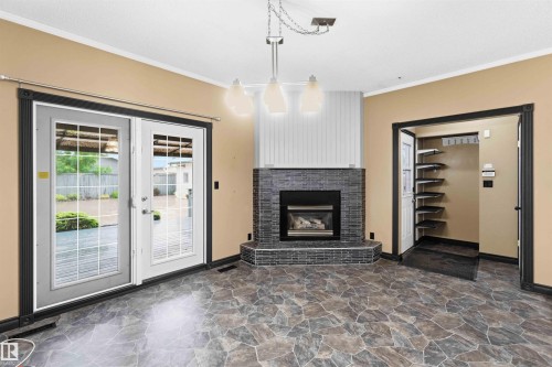 Corner fireplace with dark stone surround and white vertical paneling - 17303 107 Street, Edmonton, AB 