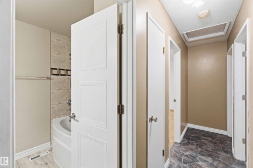 Hallway featuring dark-toned irregular tile flooring and light beige wall paint - 17303 107 Street, Edmonton, AB 