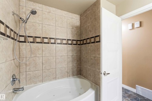 Corner bathtub with a chrome shower fixture and an integrated handheld spray - 17303 107 Street, Edmonton, AB 