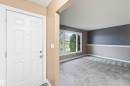 Entry foyer with a paneled white door, showcasing a gray tiled threshold and neutral wall tones - 17303 107 Street, Edmonton, AB 