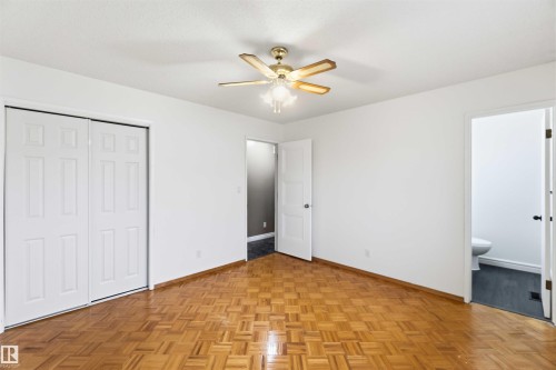 Room featuring wood-finish parquet flooring, white walls, and a ceiling fan with integrated lighting - 17303 107 Street, Edmonton, AB 