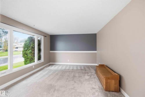 Spacious room featuring light-colored carpeting and a large multi-pane window - 17303 107 Street, Edmonton, AB 
