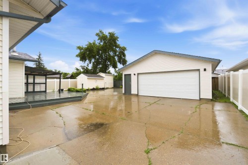 Detached garage with a white sectional door and a side entry door - 17303 107 Street, Edmonton, AB 