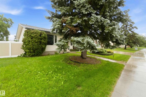 Single-story residence featuring light-colored siding, a dark shingled roof, and a prominent front window - 17303 107 Street, Edmonton, AB 
