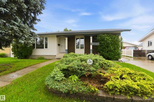 Exterior featuring light-colored siding and a brick facade accent - 17303 107 Street, Edmonton, AB 