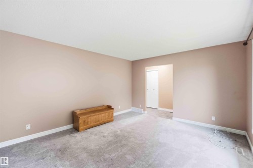 Spacious room featuring neutral-toned walls, light gray carpeting, and white baseboards - 17303 107 Street, Edmonton, AB 