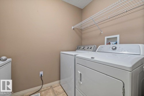 Dedicated laundry area featuring wire shelving, neutral wall paint, and tiled flooring - 8509 7 Avenue, Edmonton, AB 