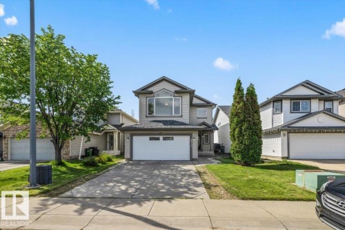 Two-story residence featuring a neutral grey exterior, attached two-car garage, and a large upper-level window - 8509 7 Avenue, Edmonton, AB 