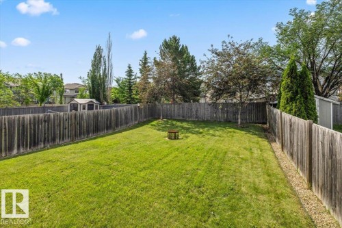 Expansive backyard featuring a manicured lawn, established perimeter fencing, and a dedicated storage shed - 8509 7 Avenue, Edmonton, AB 