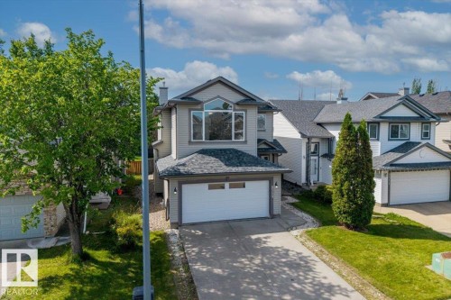 Two-story residence featuring light gray siding, an attached double-car garage, and a concrete driveway - 8509 7 Avenue, Edmonton, AB 