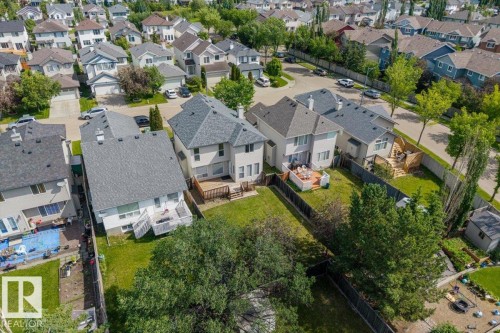 Aerial view showcasing a residential neighborhood with detached homes, each featuring gabled roofs and private yards - 8509 7 Avenue, Edmonton, AB 