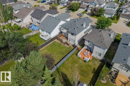 Residential property featuring light-colored siding and a dark shingle roof - 8509 7 Avenue, Edmonton, AB 