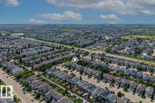 Aerial view of a residential neighborhood with numerous detached homes, tree-lined streets, and expansive green spaces - 8509 7 Avenue, Edmonton, AB 