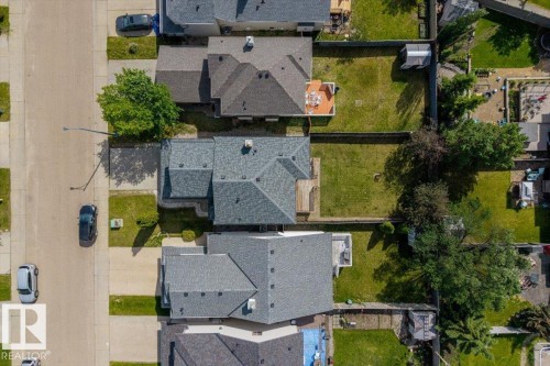Aerial perspective highlighting the property with a gray shingle roof, a paved driveway, and a front lawn - 8509 7 Avenue, Edmonton, AB 