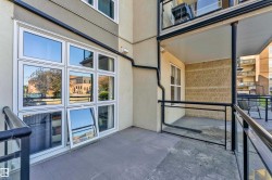 Private outdoor patio featuring a concrete surface, black metal railings, and glass panels - 