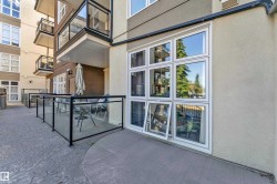 Ground-level patio featuring a glass railing and stamped concrete flooring - 