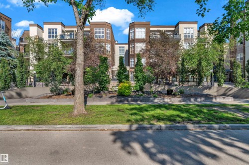 Contemporary multi-story building featuring warm-toned exterior panels, light-colored accents, numerous windows, and private balconies with dark railings - 129 10407 122 Street, Edmonton, AB 