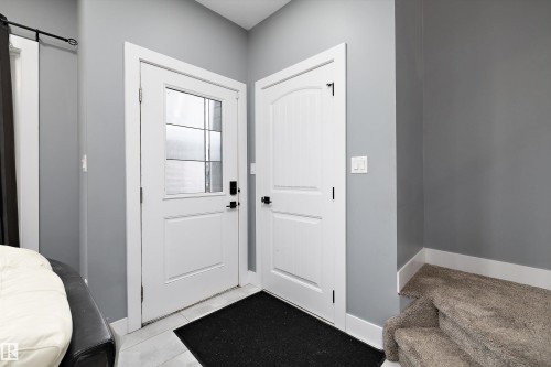 Entryway featuring a white paneled door with a frosted glass insert and dark hardware - 6084 179 Avenue, Edmonton, AB 