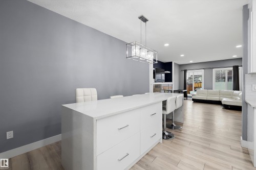 Kitchen island featuring a white countertop and integrated storage drawers with brushed nickel hardware - 6084 179 Avenue, Edmonton, AB 