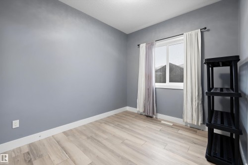 Room featuring light wood-finish flooring, light grey walls, and white baseboards - 6084 179 Avenue, Edmonton, AB 