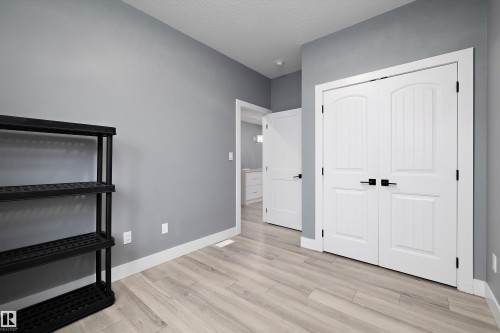 Interior space featuring light wood-finish flooring, neutral gray walls, and crisp white baseboards - 6084 179 Avenue, Edmonton, AB 