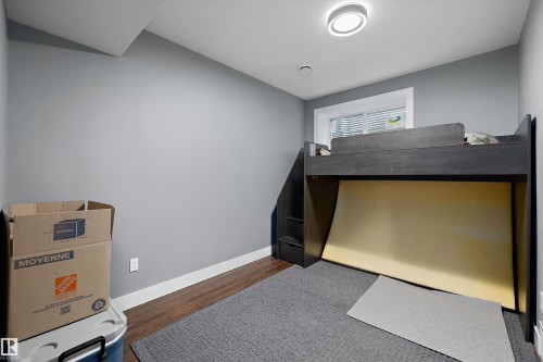 Gray painted walls with white trim, wood-finish flooring, and a flush-mount ceiling light - 6084 179 Avenue, Edmonton, AB 