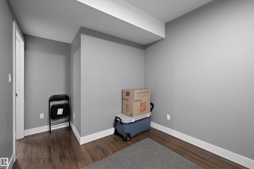 Room featuring wood-finish flooring, light grey painted walls, white trim, and a white ceiling - 6084 179 Avenue, Edmonton, AB 