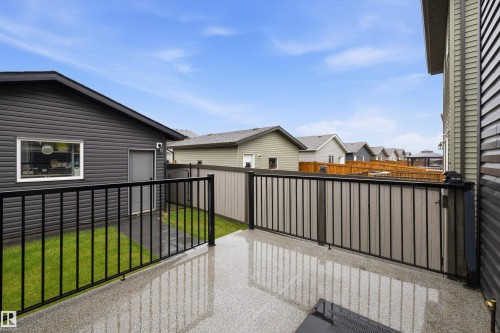 Outdoor concrete patio with black metal railing - 6084 179 Avenue, Edmonton, AB 