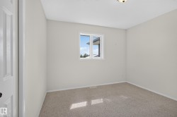 Room featuring neutral wall tones, carpeted flooring, a white-framed window, and a white paneled door - 