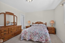 Carpeted bedroom featuring light-toned wall paint and an overhead light fixture - 