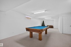 Recreational room featuring a pool table, light-colored carpeting, multiple fluorescent ceiling lights, and painted white walls - 