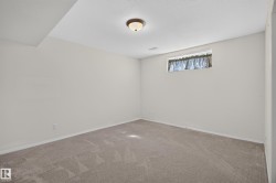 Carpeted room featuring light-colored walls, a ceiling-mounted light fixture, and a single window with a valance - 