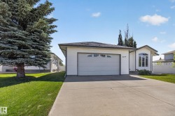White-sided residence featuring an attached garage with a decorative transom window - 