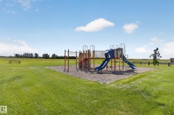 Outdoor playground featuring multiple slides and climbing structures on a soft ground surface - 