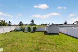 Expansive green lawn surrounded by white vinyl fencing - 