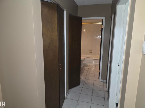 Hallway with wood-finish cabinet doors and light-toned walls - 307 11907 81 Street Nw, Edmonton, AB 