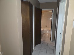 Hallway with wood-finish cabinet doors and light-toned walls - 