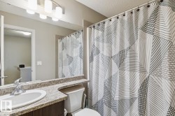 Bathroom featuring a built-in vanity with an undermount sink and a speckled countertop - 