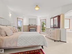 Bedroom with multiple windows, a glass covered fireplace, and carpet - 