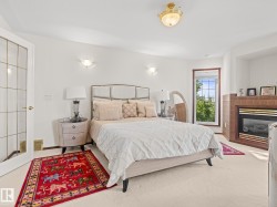 Bedroom with a glass covered fireplace and carpet floors - 