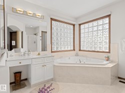 Bathroom featuring a garden tub, a shower stall, healthy amount of natural light, and vanity - 
