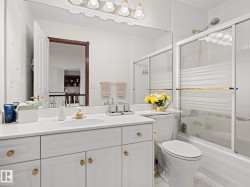 Full bathroom featuring bath / shower combo with glass door, vanity, and light tile patterned floors - 
