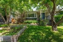Front exterior featuring a blue entry door, complementary siding, and a window box - 11634 74 Avenue Nw, Edmonton, AB 