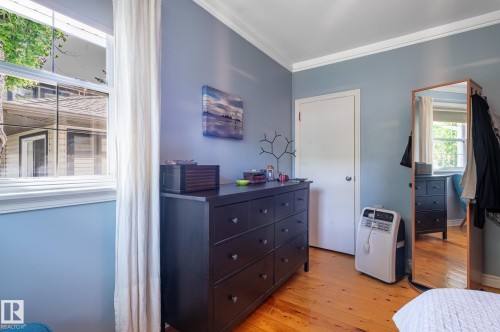 Bright room featuring a multi-pane window, wood-finish flooring, and crown molding - 11634 74 Avenue Nw, Edmonton, AB 